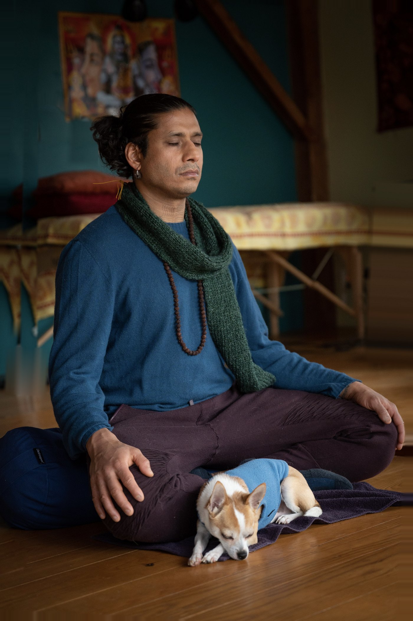 Jai meditating at home with his dog Foxy asleep beside him